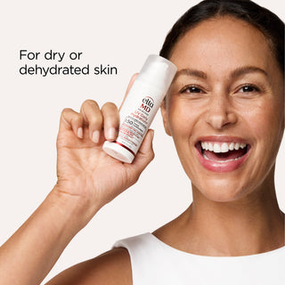 Smiling model holding a bottle of EltaMD UV Daily Hydration+ SPF 50 for dry and dehydrated skin