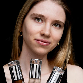 Model holding three Dr. Lara Devgan serums