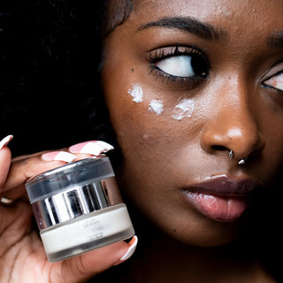 Model applying Dr. Lara Devgan Polypeptide Eye Cream under the eyes