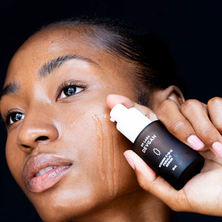 Model applying Dr. Lara Devgan serum to the face