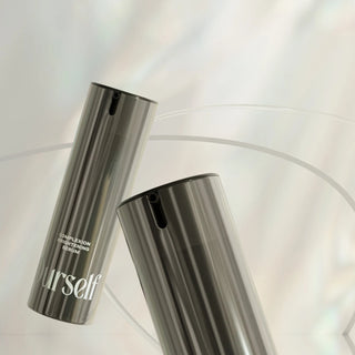 Ourself Complexion Brightening Serum bottles on an iridescent background
